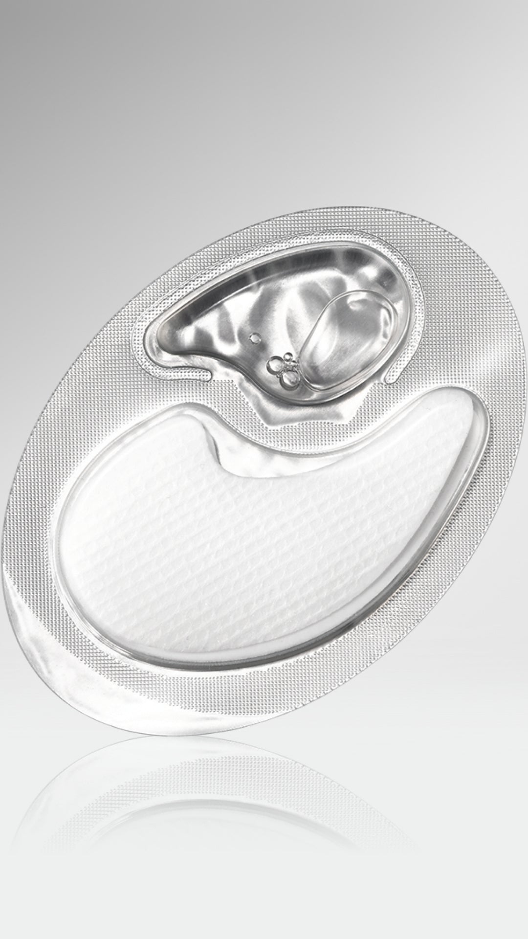 Silver electronic device on a reflective surface with a light gray background